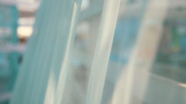 See-through mavi peçe yavaş hareket yavaş hareket te bir deniz kıyısında bir gölgelik üzerinde çırpınan şeffaf bir mavi voile etkileyici görünümü yavaş hareket yavaş hareket te güneşli bir günde kumlu bir deniz kıyısında ahşap bir gölgelik üzerinde rüzgarlı havalarda sallayarak