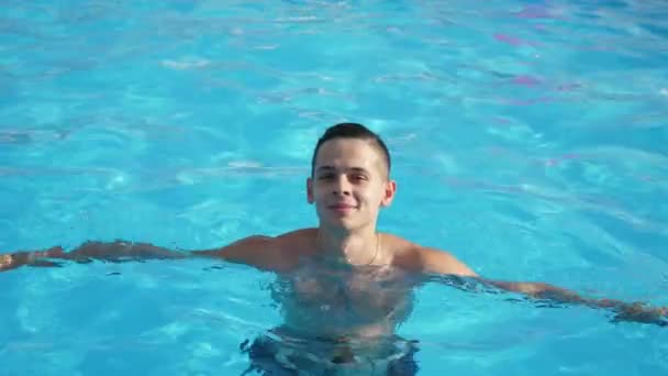 Feliz Joven Está Saltando Una Piscina Con Agua Celeste Slo — Vídeo de stock