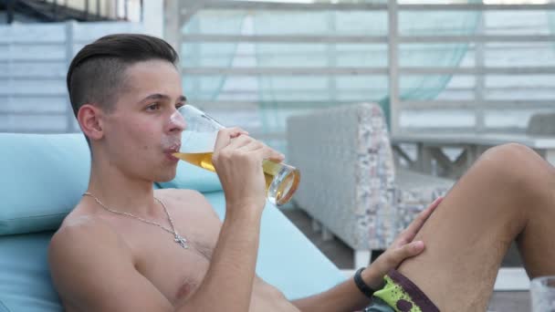 Giovane Uomo Bruno Sdraiato Lettino Che Beve Birra Una Località — Video Stock