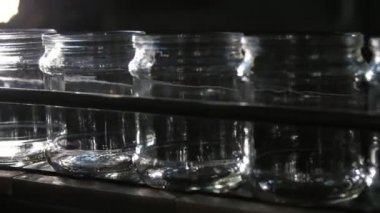 Bir domates işleme tesisinde içi boş cam bankalar, modern bir domates üretim tesisinin geniş bir koridorunda boş cam kavanozların yanıp söndüğü harika bir manzara. Son derece teknolojik ve iyi görünüyor.