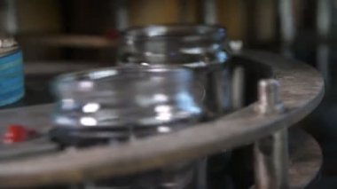 Bir domates işleme fabrikasındaki konveyör şeridinde dönen içi boş cam bankalar modern bir domates üretim tesisinin geniş bir koridorunda konveyör şeridinde hareket eden boş cam bankalarını heyecan verici bir şekilde görüyorlar. Çok neşeli ve etkileyici görünüyor..