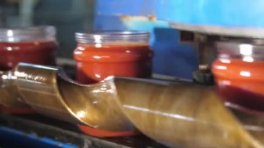 Domates bitkisinin kapağı olmadan metal bir şeritte hareket eden domates ezmesi bantları domates işleme tesisinde gözkapağı olmadan domates ezmesi kavanozlarının şaşırtıcı bir şekilde yakın plan çalışması. Yüksek teknoloji ve neşeli görünüyor..