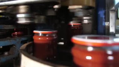 Domates yapıştırıcı bantlar, bir domates macunu bankalarının, yüksek teknolojili bir domates işleme tesisinde, yuvarlanan bir robotun altında hızla çalışan domates yapıştırıcısının muhteşem görüntüsü içinde, metal bir şeritte yanıp sönüyor.. 
