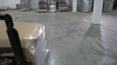 Modern bir bitkinin içinde domates konserveleriyle dolu kutuları taşıyan bir forklift. Hızlı çatal kamyonun, modern bir domates işleme tesisinde kutu kutu kutu kutu dolusu satışı çok etkileyici.