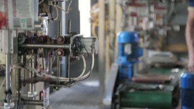 Düşen ketçap paketleriyle domates fabrikası konveyöründe çalışan modern robotlar, geniş ve havadar bir üretim salonunda düşen ketçap paketleriyle domates fabrikası konveyöründe çalışan etkileyici robotlar. Yüksek teknolojili ve iyimser görünüyor..