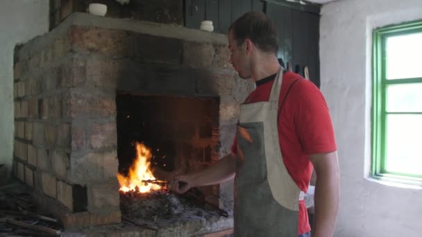 Jongeman Neemt Een Metalen Billet Van Een Ovenvuur Met Tang — Stockvideo