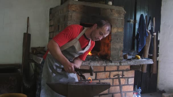 Joven Herrero Golpea Una Palanquilla Con Curvas Rojas Con Martillo — Vídeos de Stock