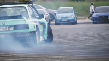 Zaporizhia, Ukrayna - 18 Mayıs 2020: Dönüşlerde kayan ve kırsalda bir otoyolda toz bulutları oluşturan sportif bir arabanın neşeli görüntüsü