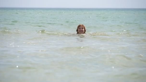 幸せな女性水泳胸のストロークで黒海で夏にスローモーション胸のブロンドの女性のエキサイティングなビュー笑顔と水泳胸のストロークでリラックスした方法で黒海の波で夏の晴れた日にスローモーション — ストック動画