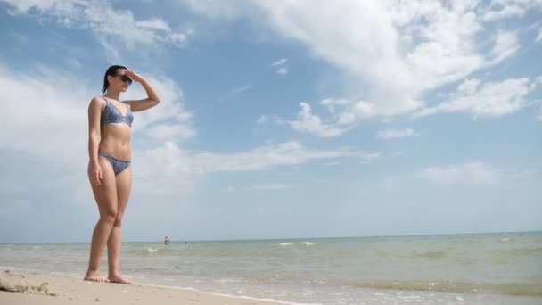 Fin Brunett Flicka Solglasögon Garvning Och Tittar Sidan Solig Havsstrand — Stockvideo