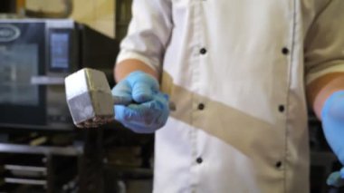Aşçı bir elden diğerine bir dokundurucu fırlatıyor mutfakta şefin ellerini neşeli bir şekilde görüyor metalik bir çekici bir elden ötekine atıyor restoran mutfağında yavaş çekimde komik görünüyor.,