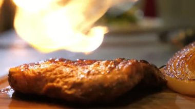 Barbekü, gaz ocağından ateşleniyor. Şef restoranda lezzetli et servisi için hazırlıyor. Ağır çekimde gaz yakıcının yardımıyla..
