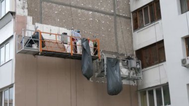 Kiev, Ukrayna-29 Haziran 2020: İki tamirci şehrin çok katlı binasından köpük bloklarını hemen kaldırdı.