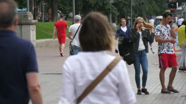 キエフ ウクライナ 2020年6月29日 エレガントな若者が歩く 電話をかける チャットや遅い動きで夏の晴れた日に緑の通りでの生活を楽しんでの元のビュー — ストック動画