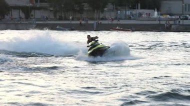 Kiev, Ukrayna-29 Haziran 2020: Bir adam gün batımında yavaş çekimde nehirde jet ski sürüyor. Etkileyici ve hoş görünüyor..