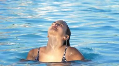 Havuzdan bikini giyen güzel bir kadın çıkar..