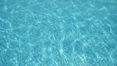 Yüzme havuzunda sallanan güzel sular, şeffaf sularla ağır çekim muhteşem bir manzara, yavaşça sallanan açık mavi sular, hipnotik bir yüzme havuzundaki güneş ışınlarıyla kaplı, güzel ve rahatlatıcı görünen çakıl taşlarıyla..