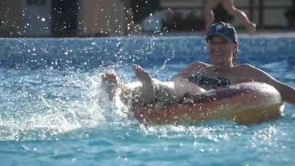 Dounut Unda Oturan Mutlu Bir Kadın Havuzda Yavaş Çekimde Bacaklarını — Stok video