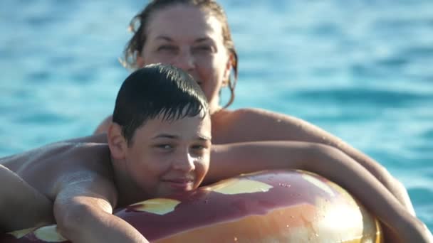 Gelukkige Jongen Met Zijn Moeder Liggend Een Donut Water Een — Stockvideo