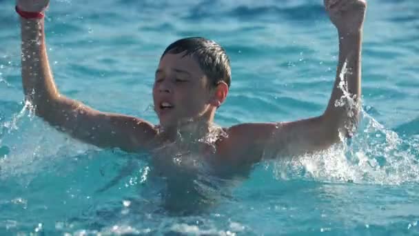 Rapaz Feliz Bate Água Com Mão Fazendo Muitas Gotas Câmera — Vídeo de Stock