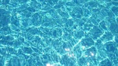 Güneşli bir yaz günü, güneşli bir günde, bir aşağı bir yukarı yüzen bir yüzme havuzunda parlayan Celeste sularının sakin bir şekilde sallanışının ve güneşli bir yaz gününde güneş ışınlarıyla oynayan bir elmasa benzeyen bir elması şekillendirmesinin muhteşem arka plan görüntüsü.