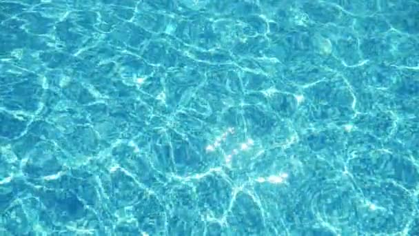夏天阳光灿烂的日子里 明亮的蓝色海水平静地摇曳着 形成了一个液体的形状 在夏天阳光灿烂的日子里 闪烁着光芒在游泳池里嬉戏 — 图库视频影像
