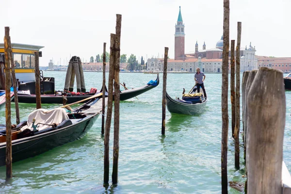 ВЕНИЦИЯ, ИТАЛИЯ - МАЙ, 2017: Венецианский гондольер пробивает гондолу через воды зеленого канала Венеции — стоковое фото
