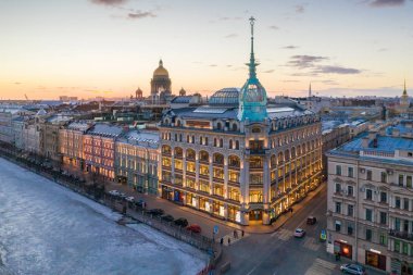 St. Petersburg, Rusya - Mart, 2019: Red Bridge yakınında mağaza mağazası sınıfı lüks. Arka planda şehir ve St Isaac Katedrali, gün batımında akşam