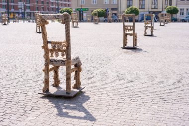 Krakow, Polonya - Haziran 2017: Yahudi gettosu anısına dikilen arnavut kaldırımlı sokakta demir sandalyeli sanat objeleri. Popul ile Krakow. 800.000, 2,35 milyon vardır. yabancı turistler yıllık