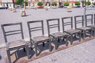 Krakow, Polonya - Haziran 2017: Yahudi gettosu anısına dikilen arnavut kaldırımlı sokakta demir sandalyeli sanat objeleri. Popul ile Krakow. 800.000, 2,35 milyon vardır. yabancı turistler yıllık