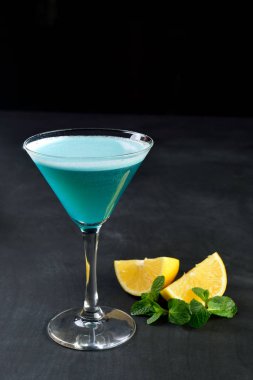 Limon nane koyu arka plan ile martini cam Mavi soğuk kokteyl