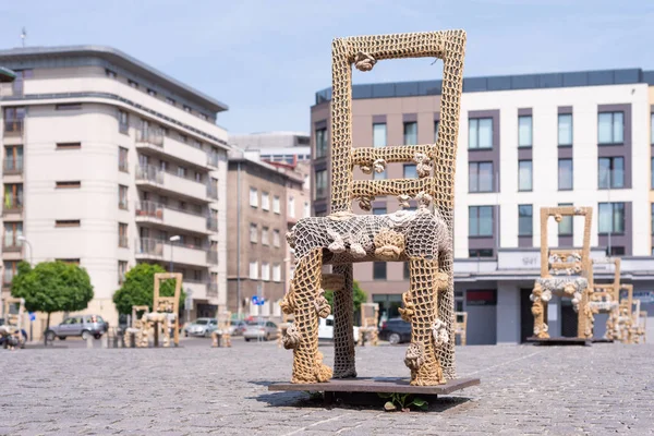 KRAKOW, POLAND - JUNE, 2017: Massive chair on cobblestone street in art installation in memory of Jewish ghetto. Krakow with popul. of 800,000 people has 2.35 mill. foreign tourists annually — Stock Photo, Image