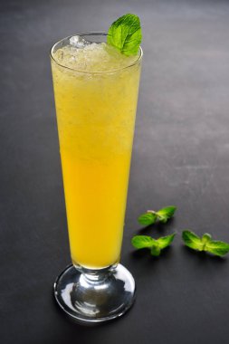 Yüksek bir bardakta buz gibi narenciye kokteyli. Menü için kopyalama alanı ile koyu arka plan.