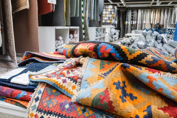 Muchas alfombras, diferentes colores, una gran opción en la tienda . —  Fotos de Stock