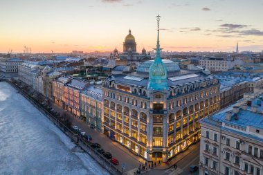 St. Petersburg, Rusya - Mart, 2019: Red Bridge yakınında mağaza mağazası sınıfı lüks. Arka planda şehir ve St Isaac Katedrali, gün batımında akşam