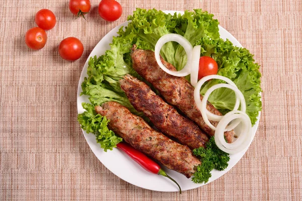 Lula kebab is a traditional Arabic dish. Meat shashlik on  with tomato. The top view — Stock Photo, Image