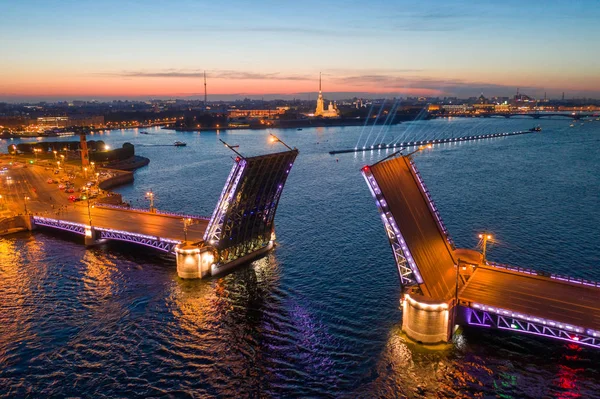 Símbolo clásico de las Noches Blancas de San Petersburgo: una vista romántica del puente abierto del Palacio, que se extiende entre la torre de Pedro y la fortaleza de Pablo — Foto de Stock