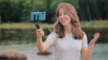 Genç, tatlı bir kız telefonda video modunda konuşuyor.