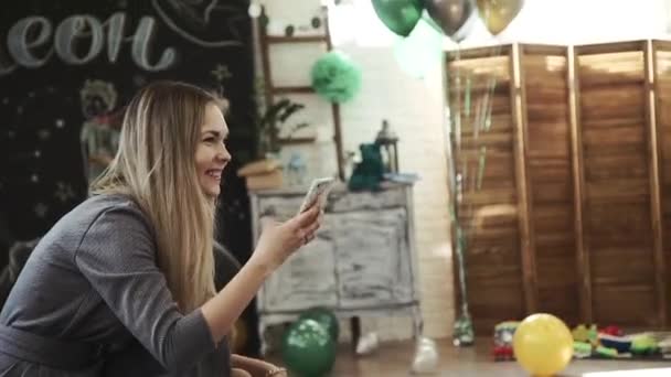 Jonge moeder schudt een klein meisje op een schommel en schiet op de telefoon — Stockvideo