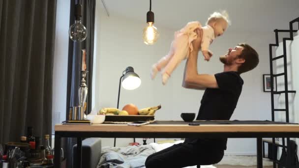 Joven papá vomita bebé pequeña hija en casa — Vídeos de Stock