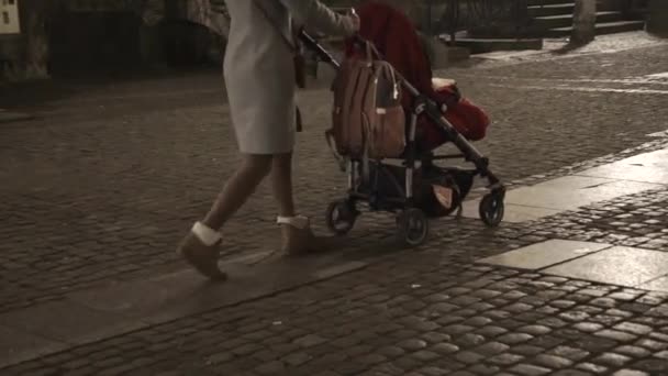 Mladá žena s dcerou v červeném kočáře v noci Gdaňsk Polsko — Stock video