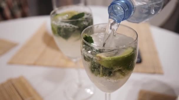 Mojito koktajl Making, woda gazowana przelewa się do szklanki z mięty i wapna — Wideo stockowe