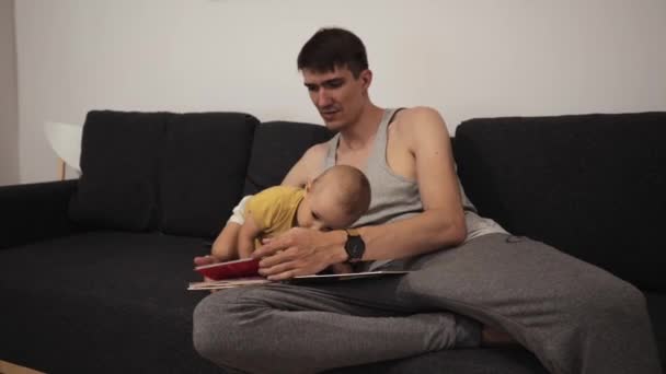 Young dad reads a book for children — Stock Video