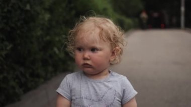 küçük kıvırcık kız yakın portre omuz silkiyor ve döner