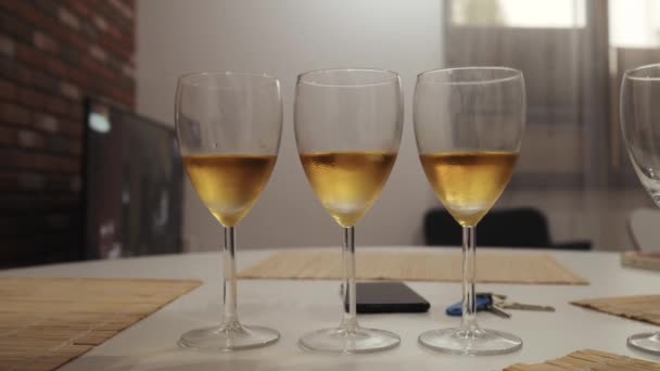 Three glasses of champagne on the table in the kitchen closeup — Stock Video