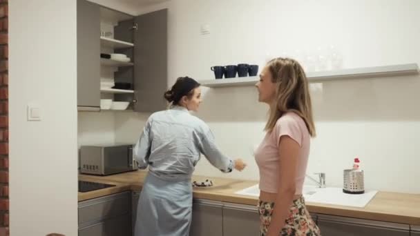 Mulheres jovens de pé namoradas falando na cozinha — Vídeo de Stock