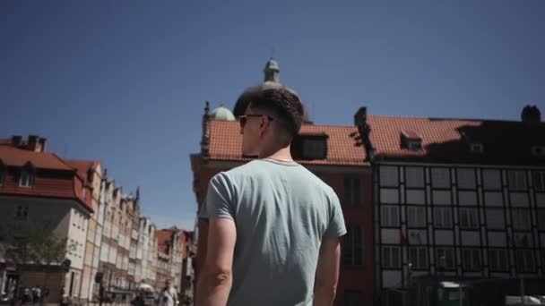 Ein Mann mit Sonnenbrille ein Tourist geht durch europäische Straßen — Stockvideo