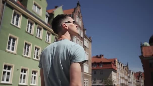 Человек в солнцезащитных очках турист ходит по европейским улицам — стоковое видео