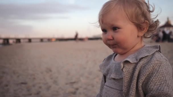 Piccola ragazza riccia mangiato sabbia insapore sulla spiaggia e sputa e colpi di scena — Video Stock