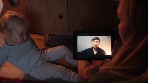 En kvinna med ett barn talar via videolänk med släktingar — Stockvideo